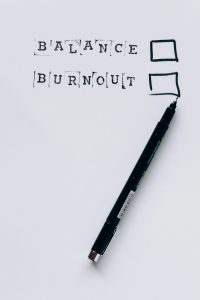 A pen beside checkboxes labeled 'Balance' and 'Burnout' to emphasize employee wellness programs.